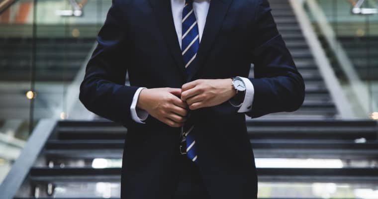 Businessman adjusting his suit jacket.