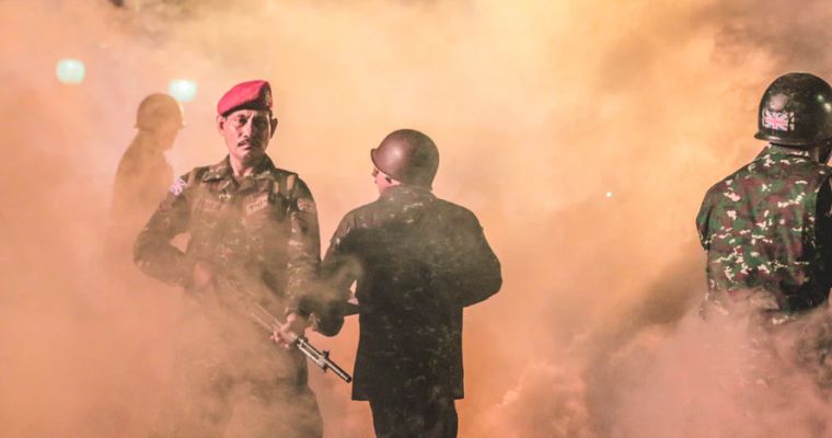 Soldiers in smoke with rifles.