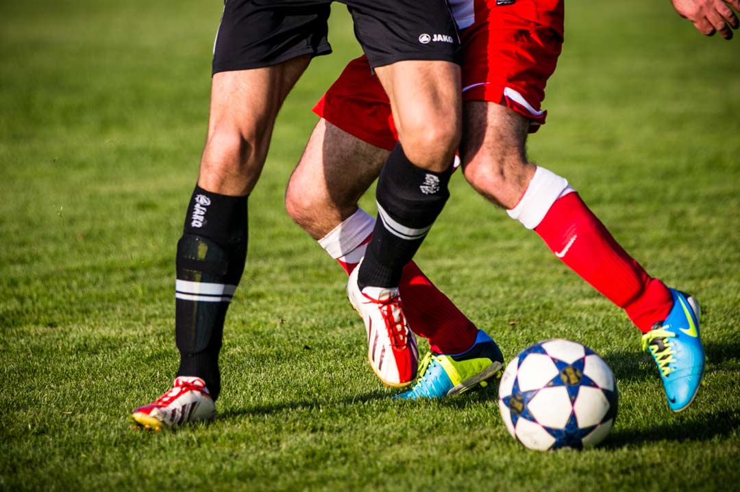 Soccer players compete for the ball.