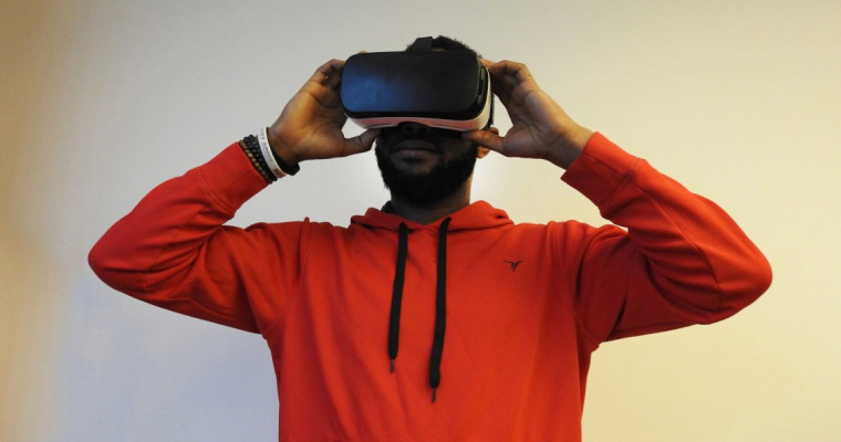 Man wearing VR headset in red hoodie.