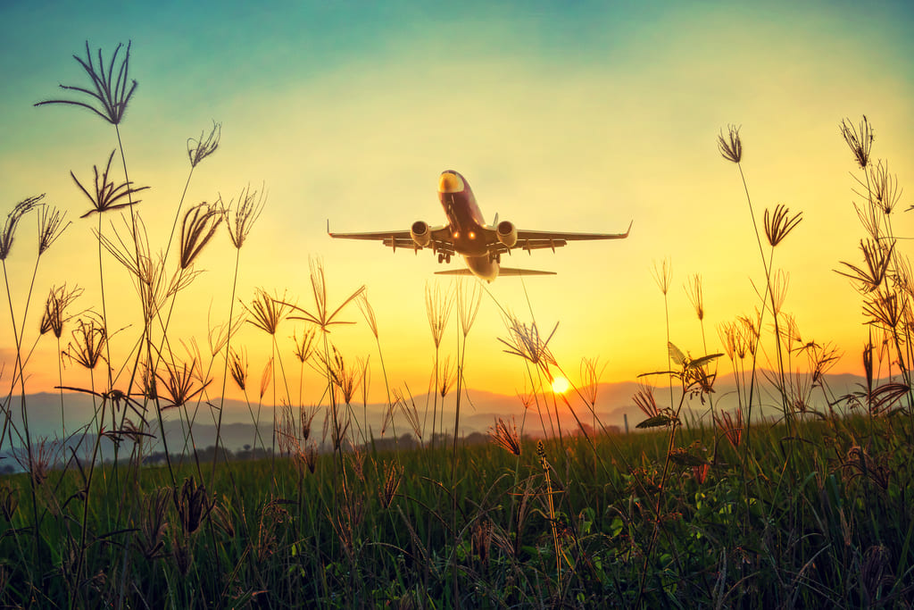 Airplane taking off at sunset.