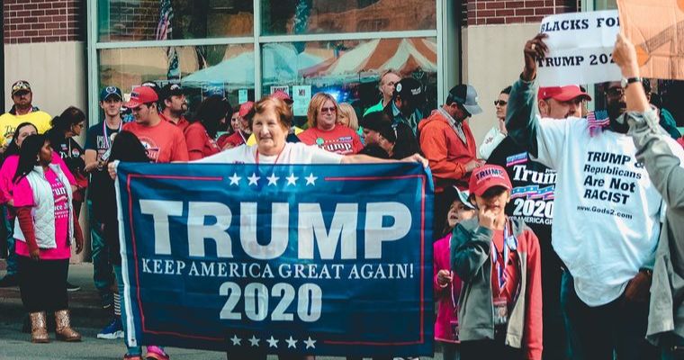 Trump 2020 rally with supporters holding signs.